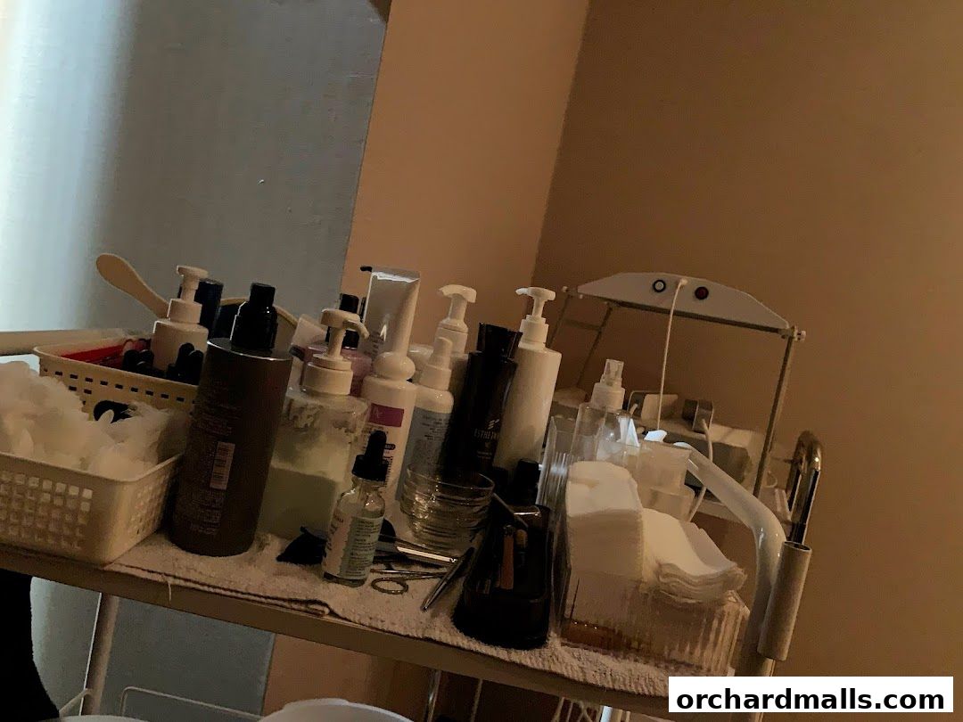 A trolley filled with various skincare products and cotton pads.