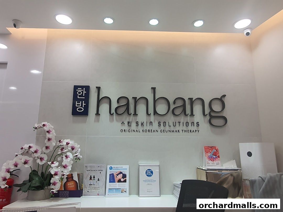The Hanbang Skin Solutions logo and decor, featuring orchids and promotional materials.
