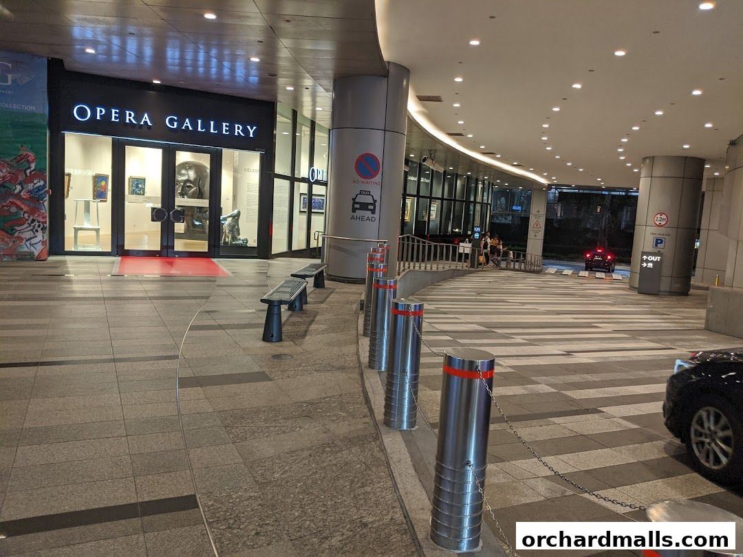 The entrance to Opera Gallery, featuring artwork displayed in the windows and a modern architectural design.