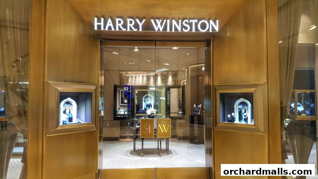 The elegant entrance of a Harry Winston jewelry and watch store with illuminated displays.