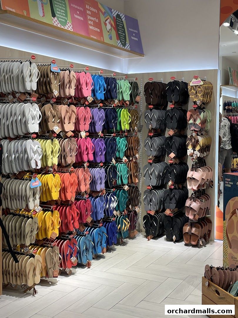 A wide selection of colorful Havaianas flip-flops displayed on shelves in a retail store.