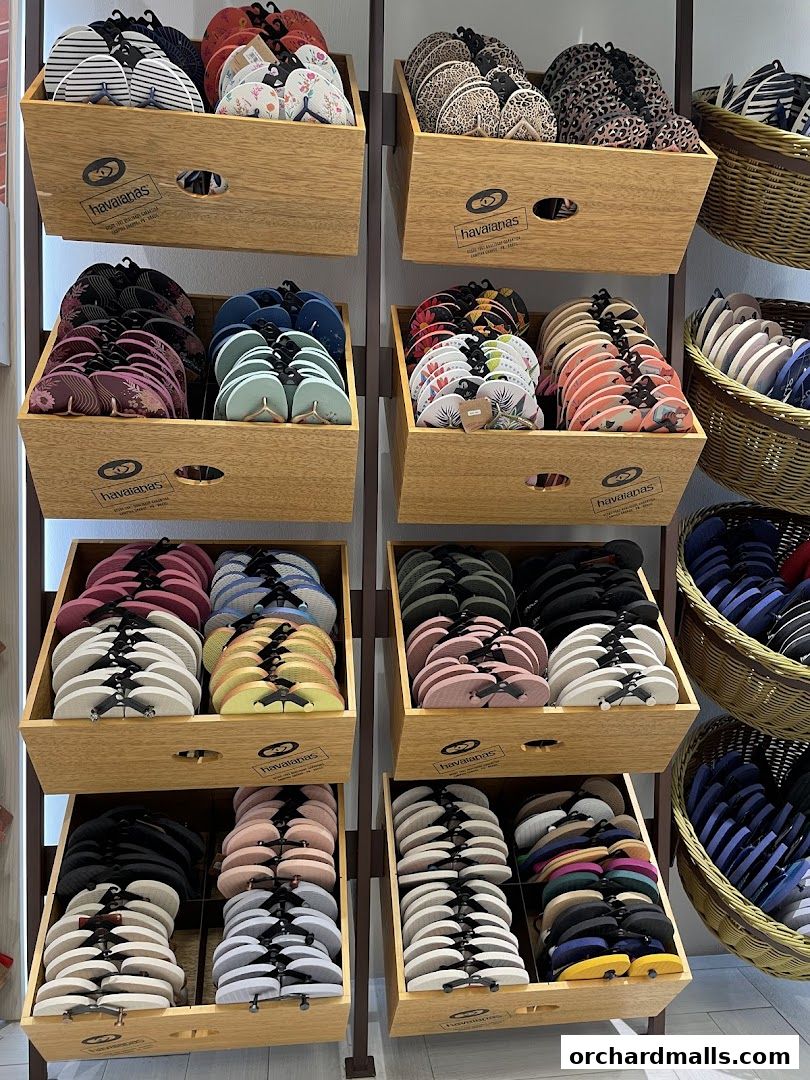 A display of colorful Havaianas flip-flops organized in wooden crates and baskets.