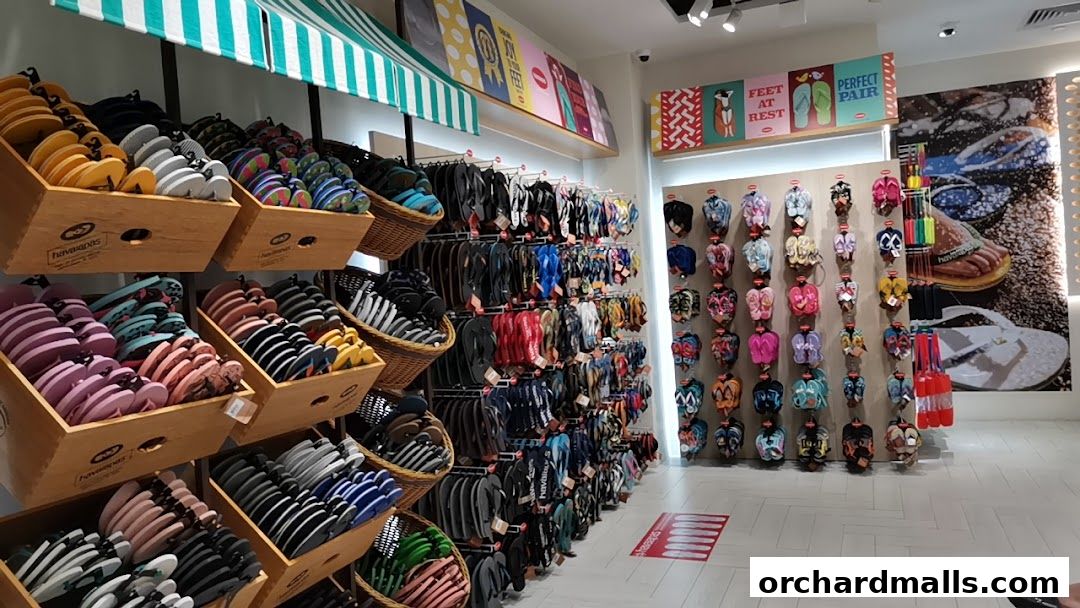 A wide selection of colorful Havaianas flip-flops displayed in wooden crates and on wall racks.