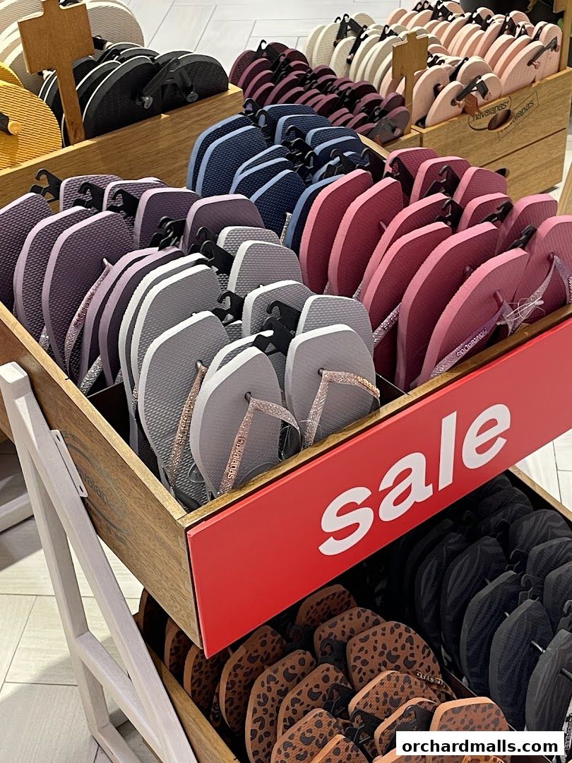 A display of colorful Havaianas flip-flops in various styles and colors, with a prominent 'sale' sign.