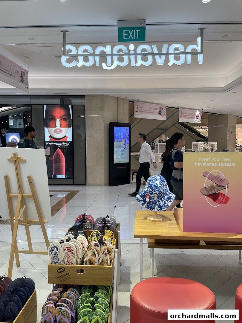 Havaianas shop front displaying colorful flip-flops and sandals, with an exit sign above.
