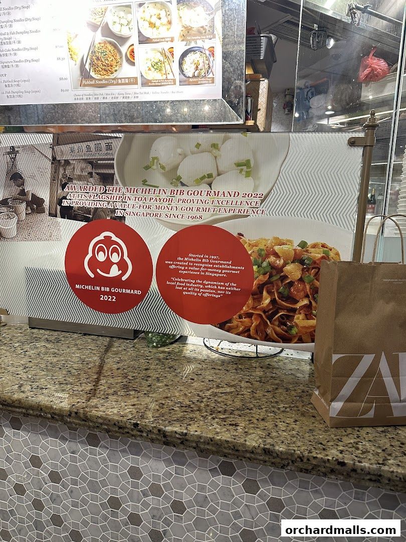 A display showcasing Hawkers Street ION's Michelin Bib Gourmand award and menu items.