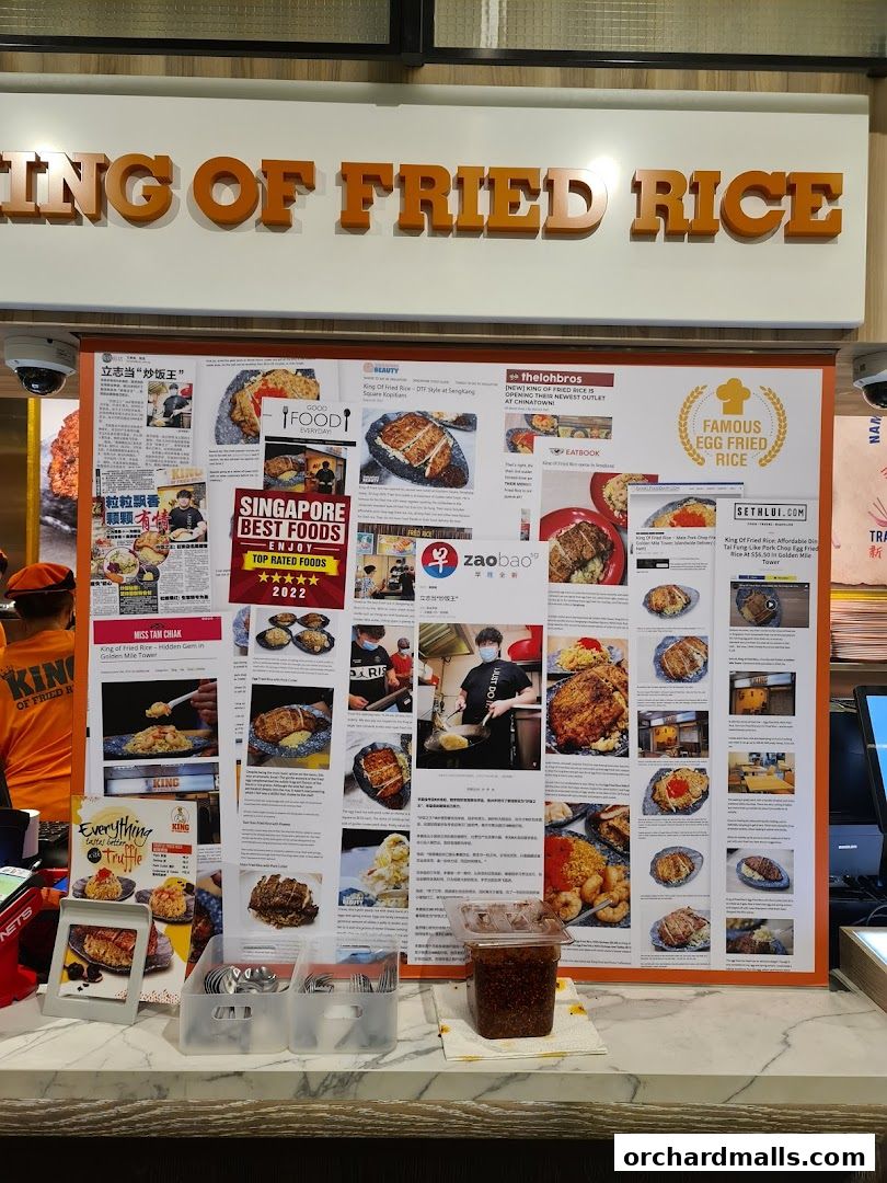 A display board showcasing news articles and photos of King of Fried Rice's dishes and outlets.