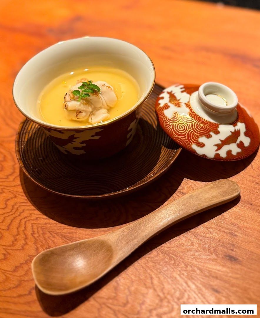 A close-up of a delicate steamed dish with seafood and a decorative lid.