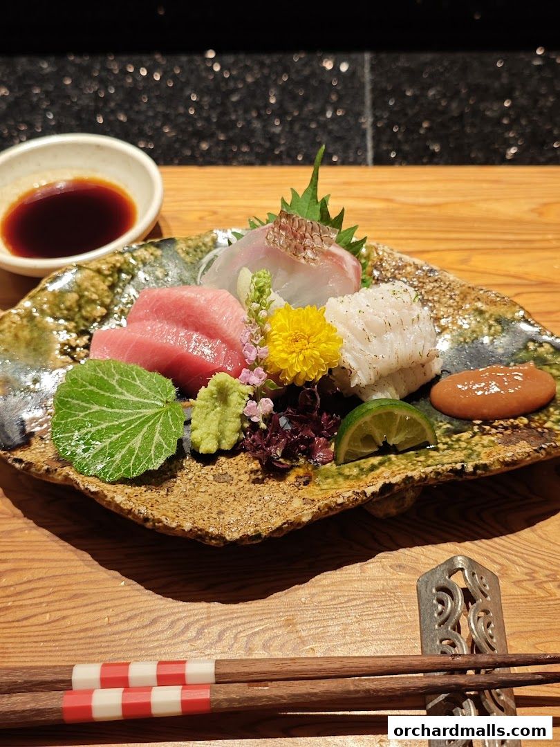 A beautifully presented sashimi platter with various types of fish, wasabi, and soy sauce.