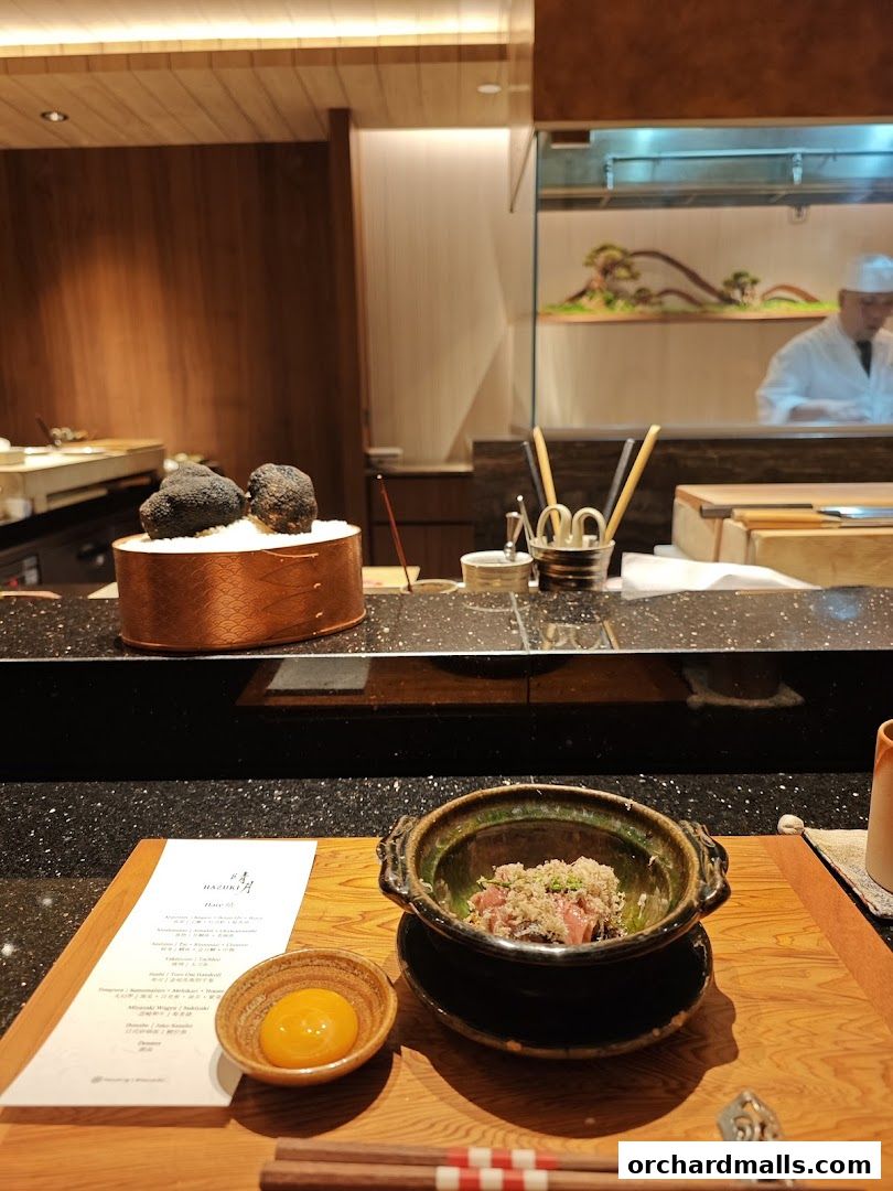 A beautifully presented dish with truffles and a raw egg yolk at Hazuki restaurant.