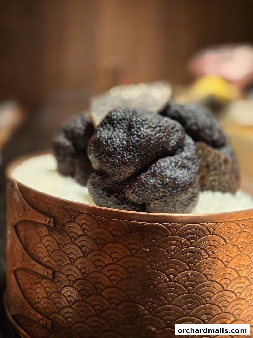 A close-up of black truffles artfully presented in a decorative copper bowl.