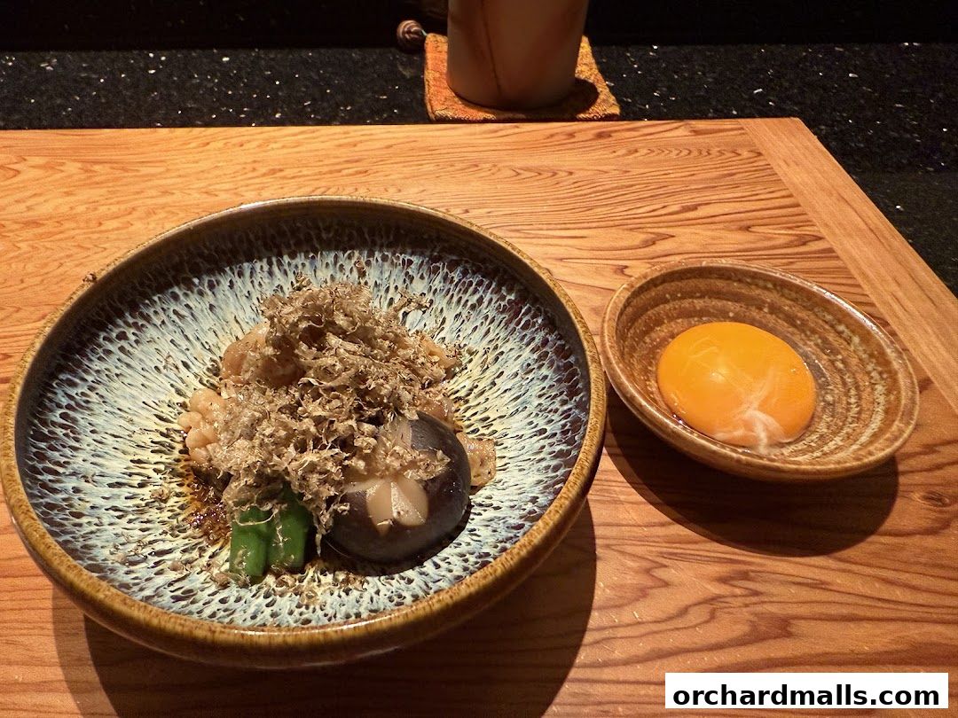 A beautifully presented dish with truffle shavings and a side of raw egg yolk.