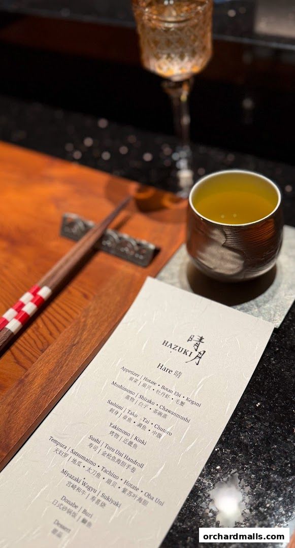 A menu from Hazuki restaurant with Japanese dishes and a cup of tea.