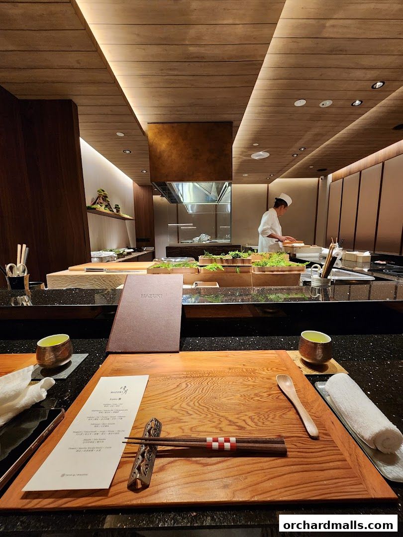 A meticulously set dining table at Hazuki, featuring a menu, chopsticks, and tea.