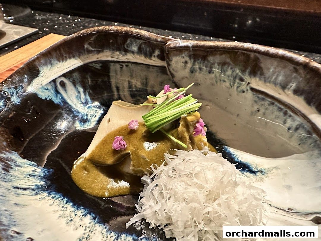 A beautifully presented dish with delicate garnishes in an artistic ceramic bowl.