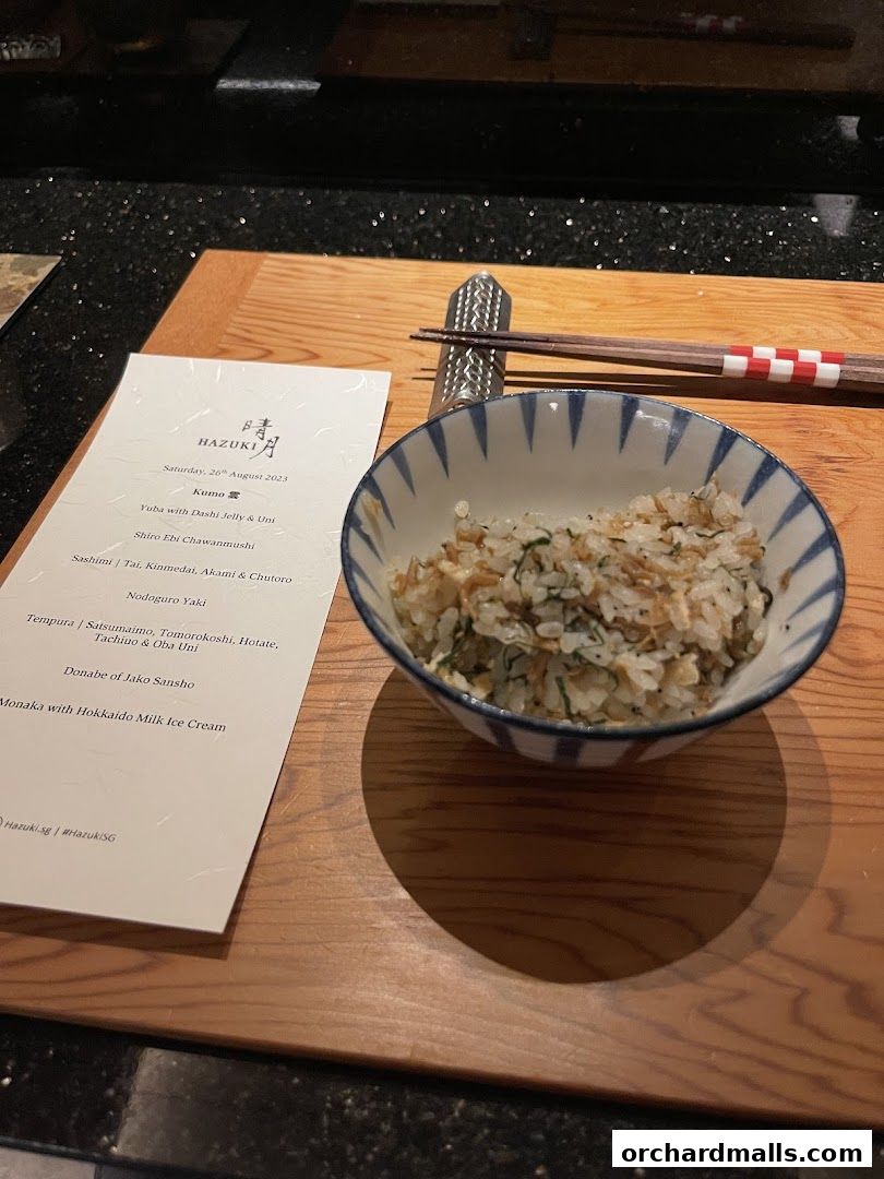 A menu from Hazuki restaurant with a bowl of rice and chopsticks.