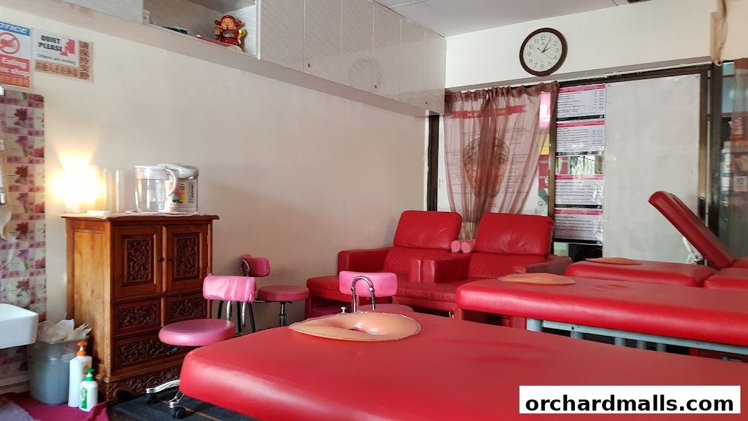 Interior of a foot care shop with red massage beds and chairs.