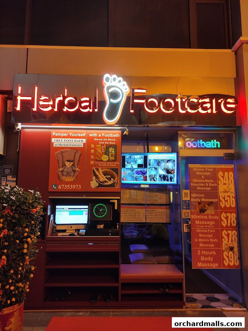 The storefront of Herbal Footcare, featuring a neon sign, service menu, and seating.