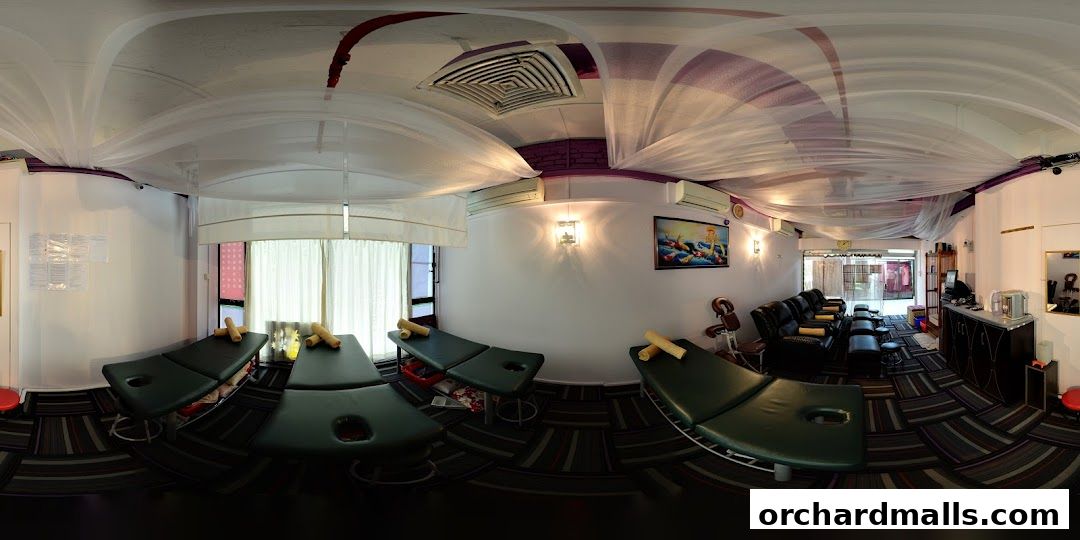 Interior view of a spa with massage beds, seating, and reception area.