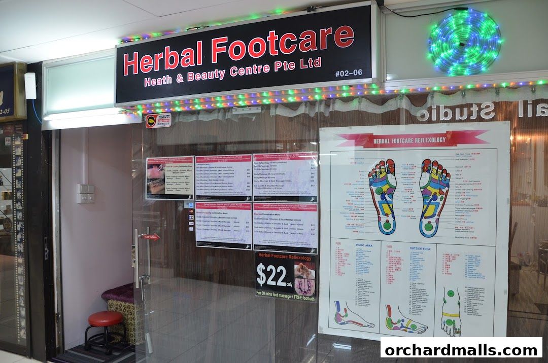 Shop front of Herbal Footcare, displaying services and prices on the glass door.