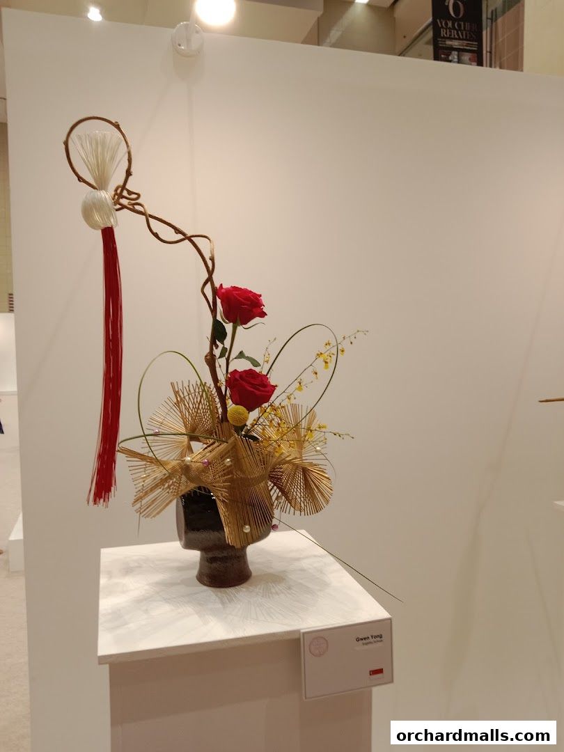 An artistic floral arrangement with red roses and decorative elements.