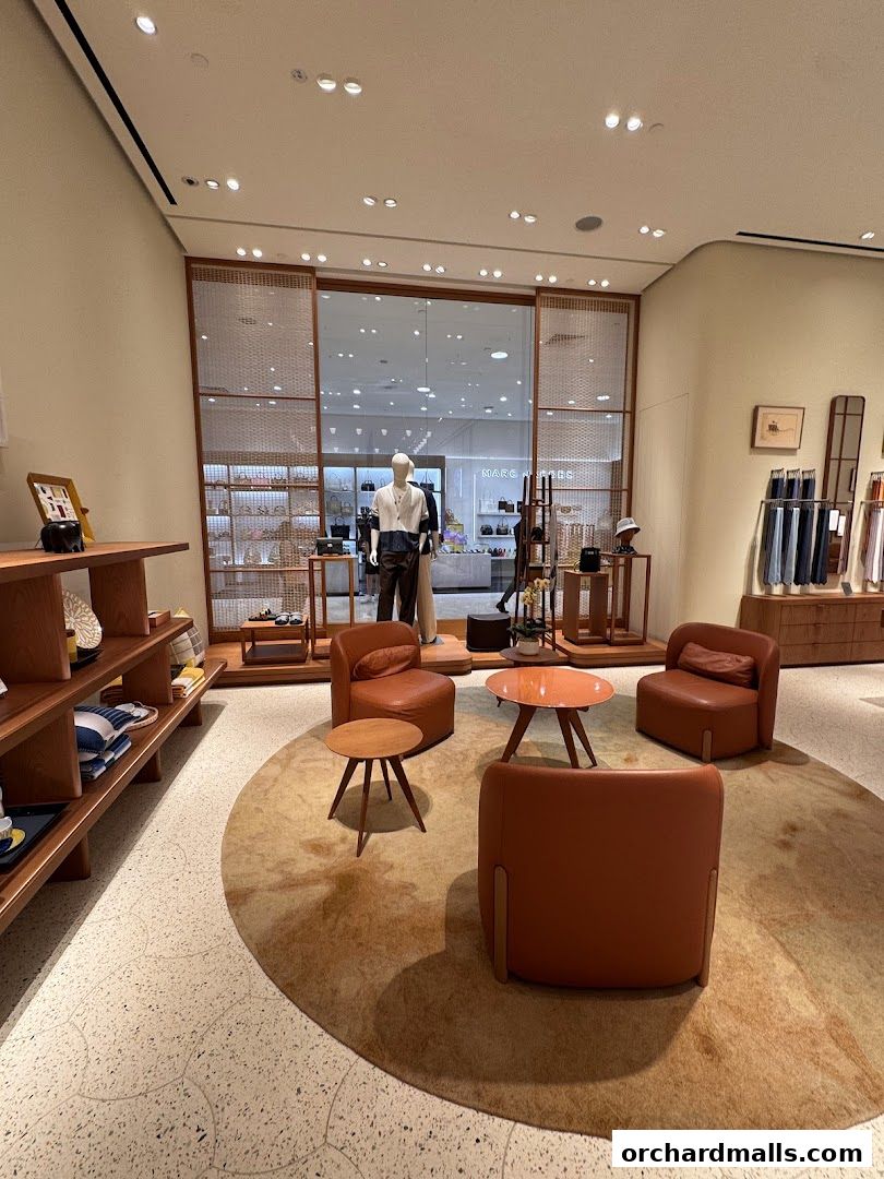 Interior of a luxury fashion store with seating area and displays.