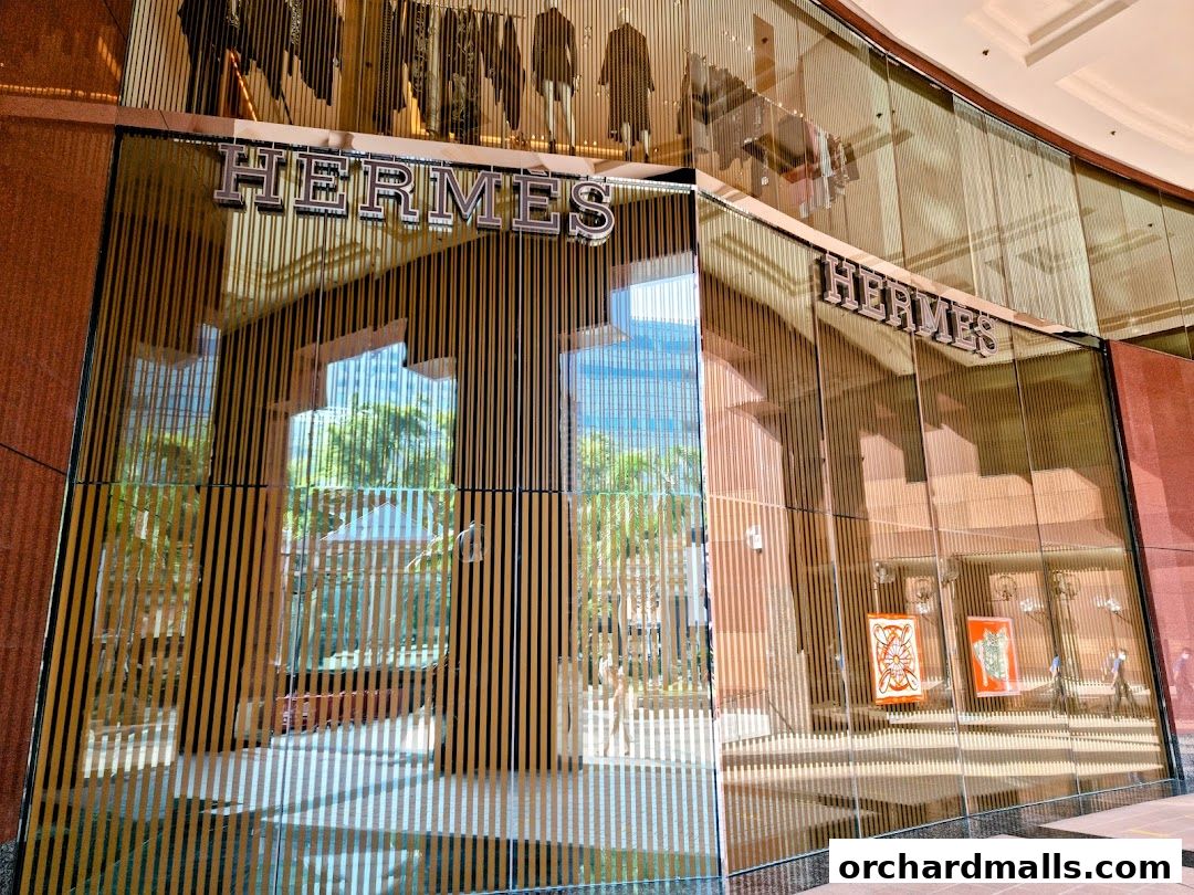 The exterior of the Hermès Singapore Takashimaya store, featuring its iconic logo and elegant window displays.