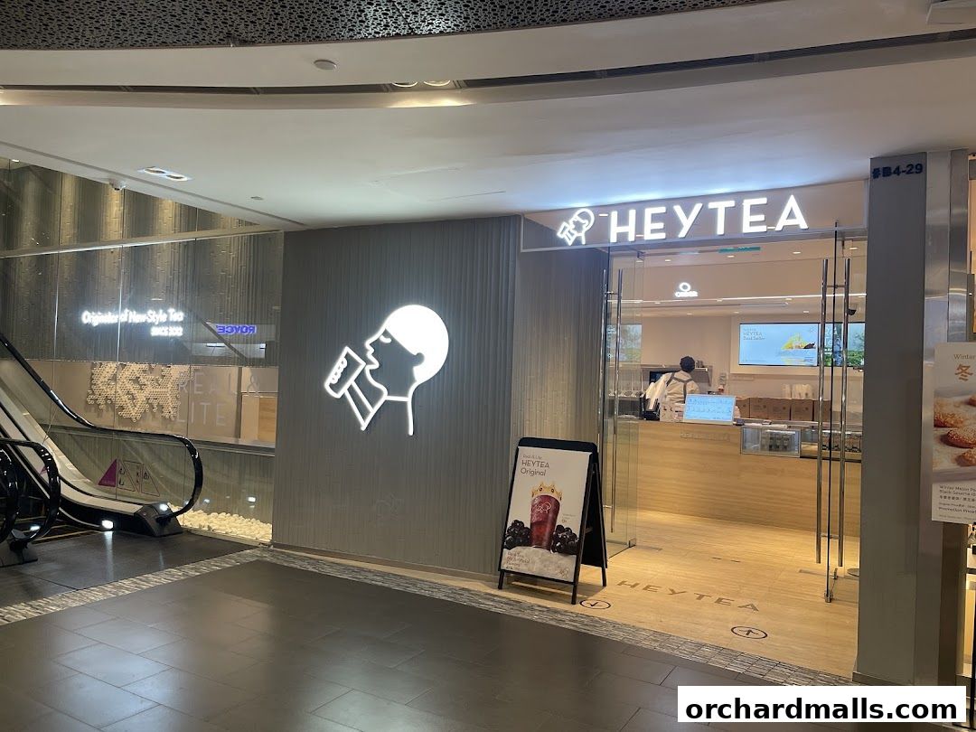 The exterior of a HEYTEA shop with its signature logo and a promotional A-frame sign.