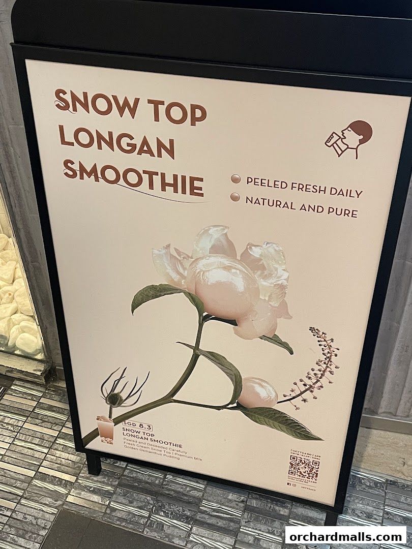 A-frame sign advertising HEYTEA's Snow Top Longan Smoothie with floral imagery.