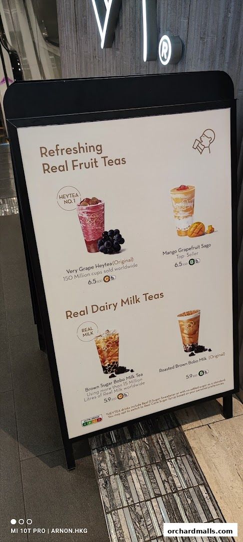 A-frame sign displaying HEYTEA's refreshing real fruit and dairy milk teas with prices.