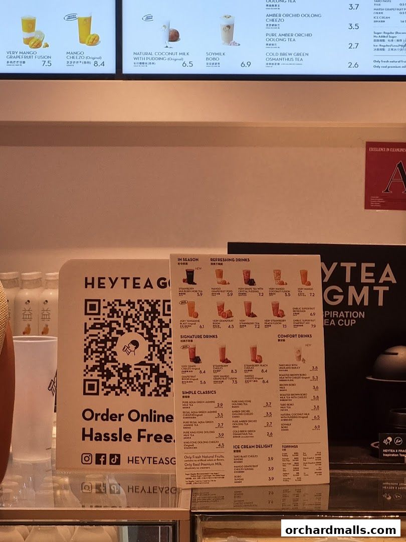 A menu board for HEYTEA featuring various drinks and toppings with prices.