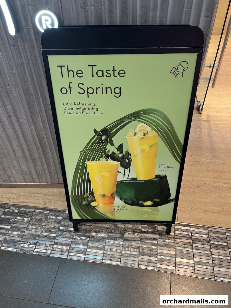 A sign advertising HEYTEA's spring drinks, featuring two citrus-themed beverages.