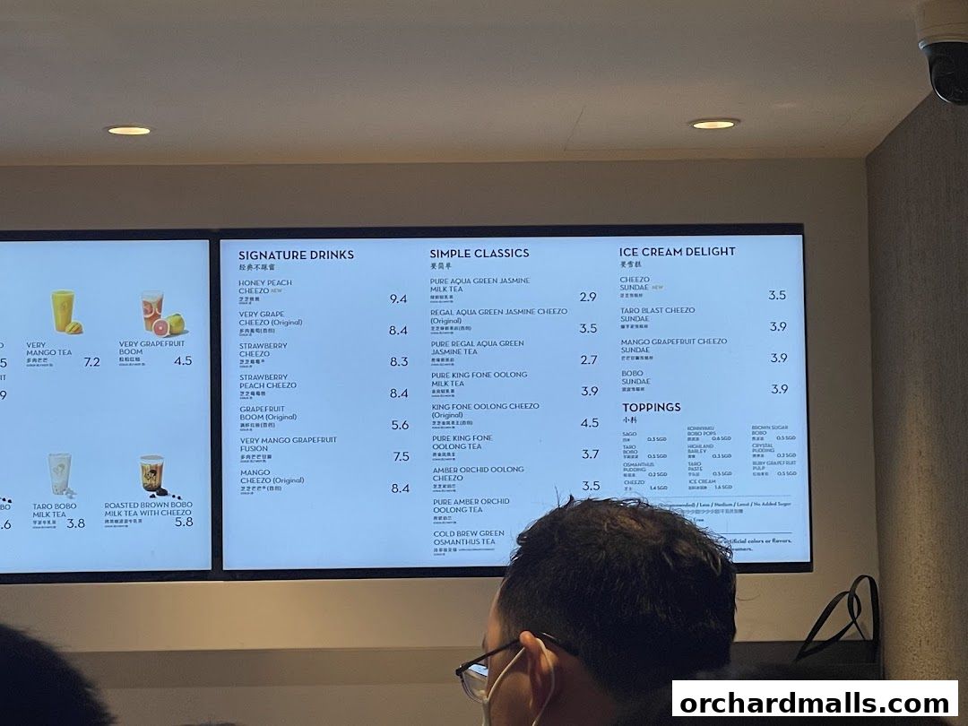 A menu board displaying various signature drinks, simple classics, ice cream delights, and toppings.