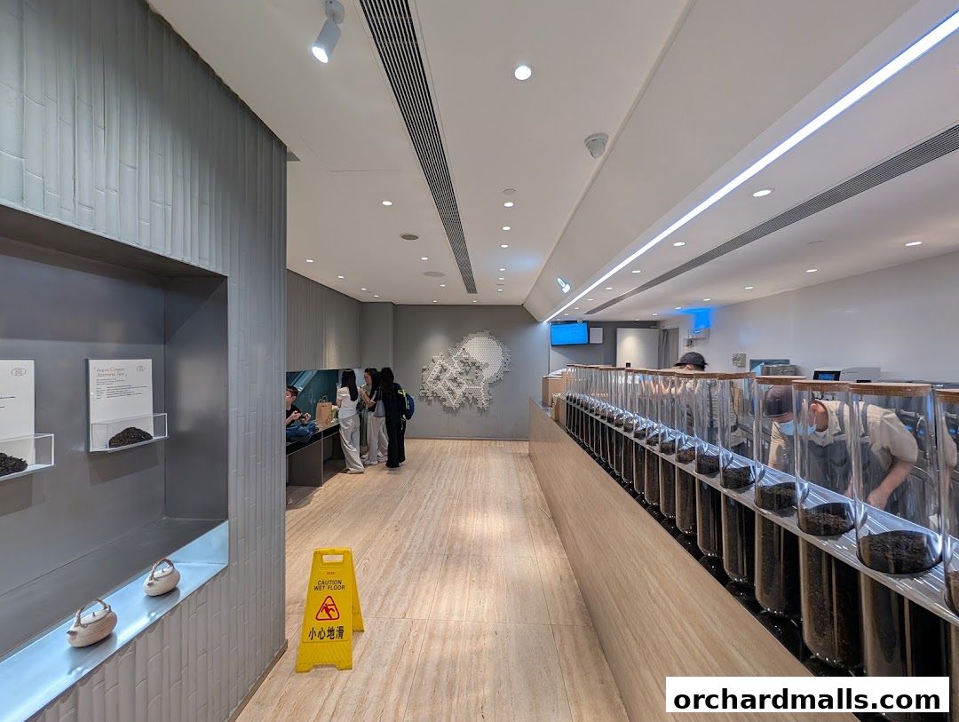 Interior of a modern tea shop with a display of teas and customers being served.