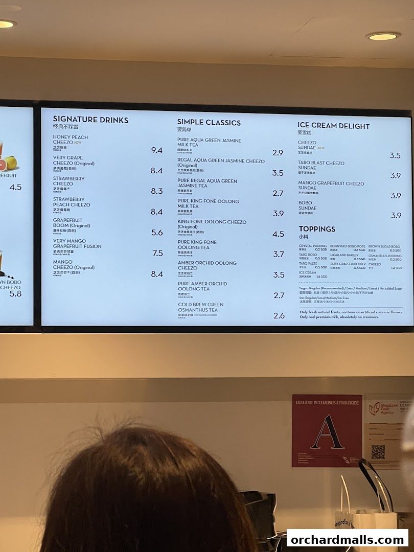 A menu board displaying various signature drinks, simple classics, ice cream delights, and toppings.