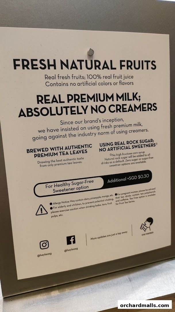 A sign detailing the ingredients and philosophy of HEYTEA, emphasizing fresh fruits and premium milk.