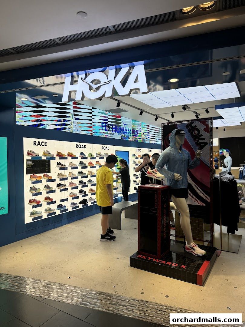 Interior of a HOKA shoe store with displays of running shoes and mannequins.