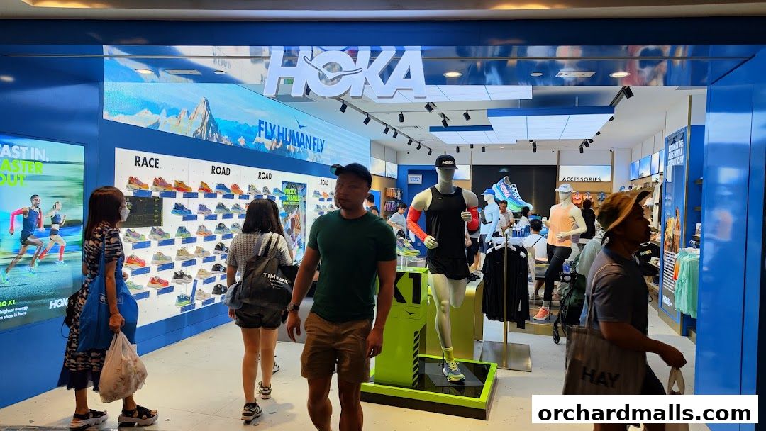 Interior view of a HOKA shoe store with displays of running shoes and mannequins.