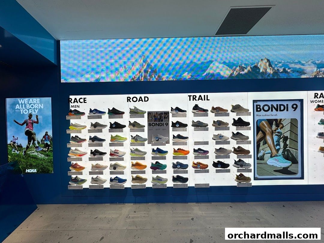 HOKA store interior displaying various running shoes categorized by race, road, and trail.