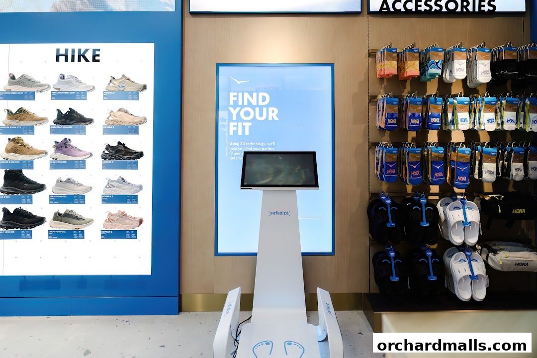Hoka store interior featuring a shoe fitting station and display of hiking shoes and accessories.