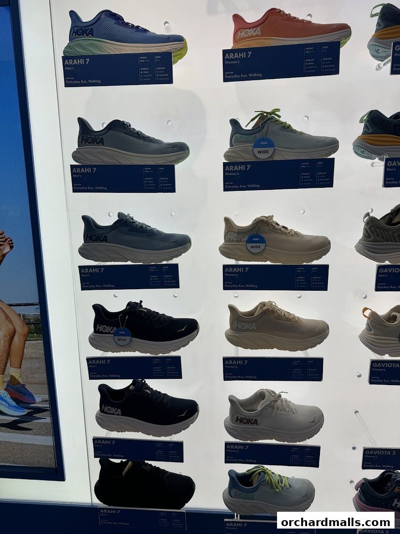 A display of various HOKA running shoes, showcasing different models and colors.