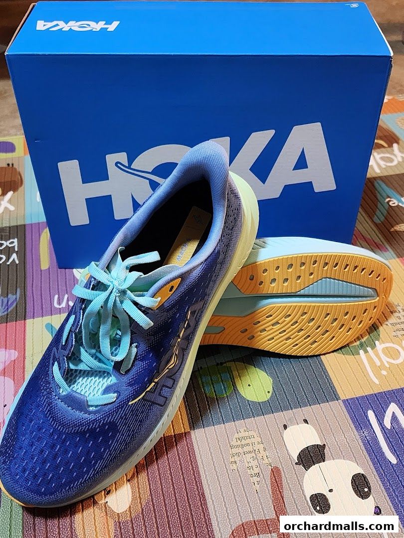 A pair of blue HOKA running shoes with a HOKA box in the background.