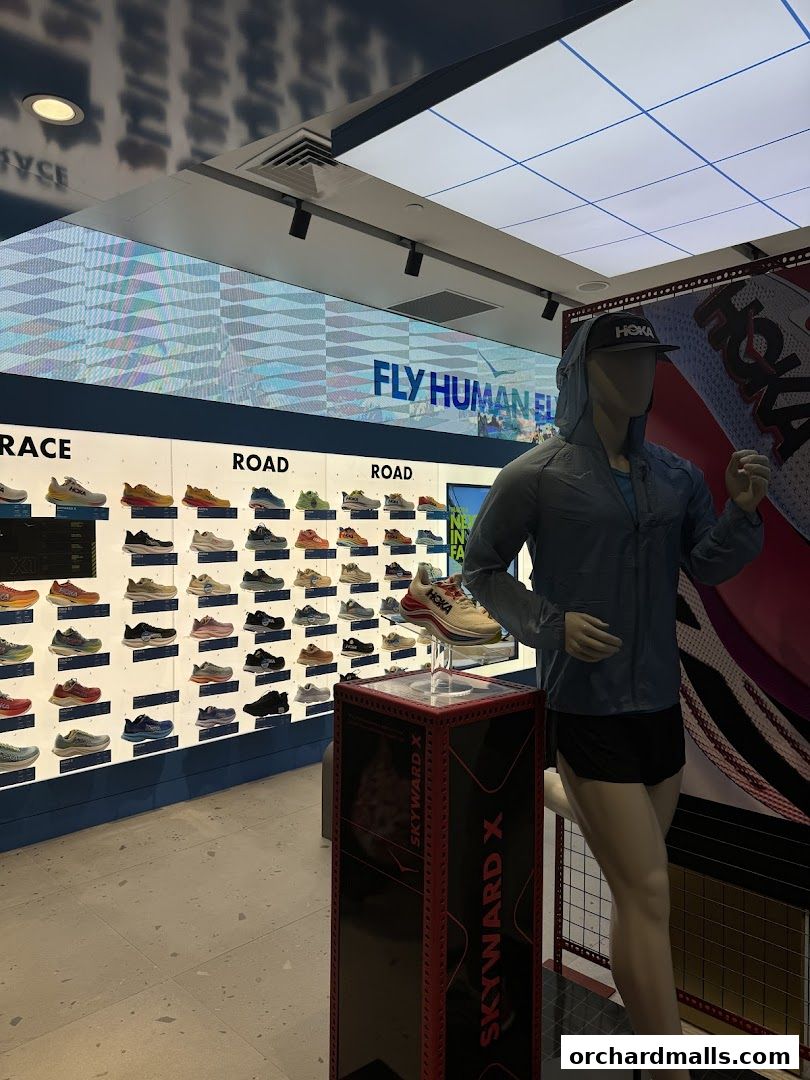 Interior of a HOKA shoe store with a mannequin and a wall display of shoes.