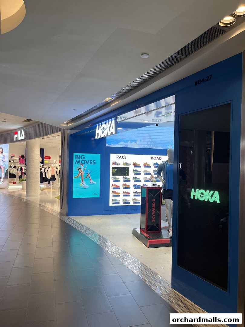The HOKA Orchard store entrance with displays of shoes and marketing posters.