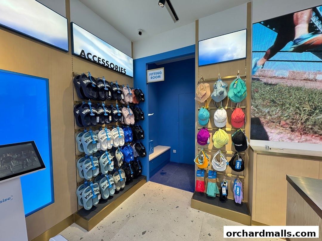 Interior of a HOKA store showcasing sandals and hats, with a fitting room visible.