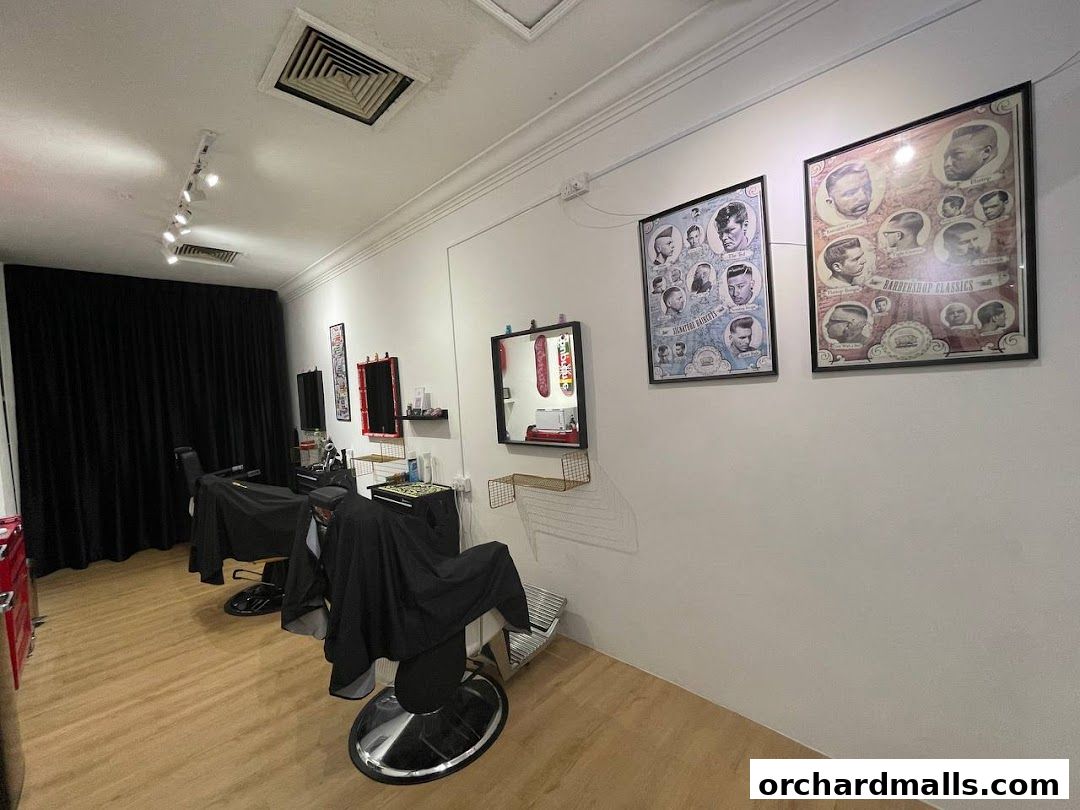 Interior of a barbershop with chairs, mirrors, and framed haircut inspirations.