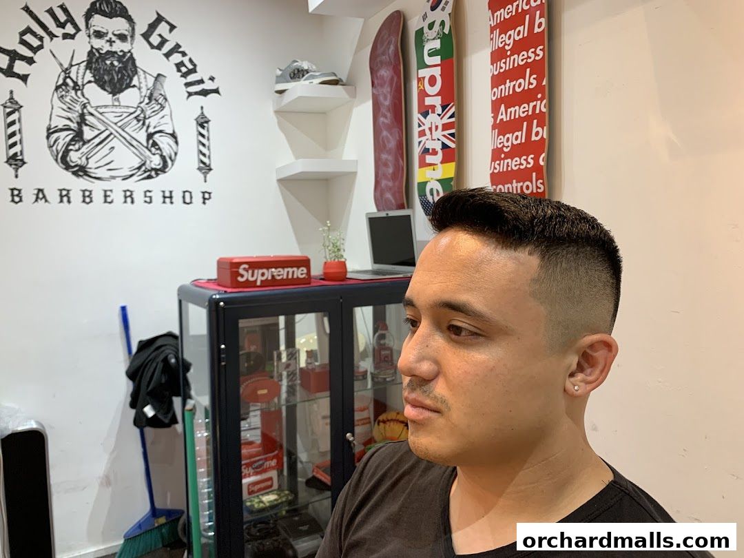 A man with a fresh haircut inside Holy Grail Barbershop.