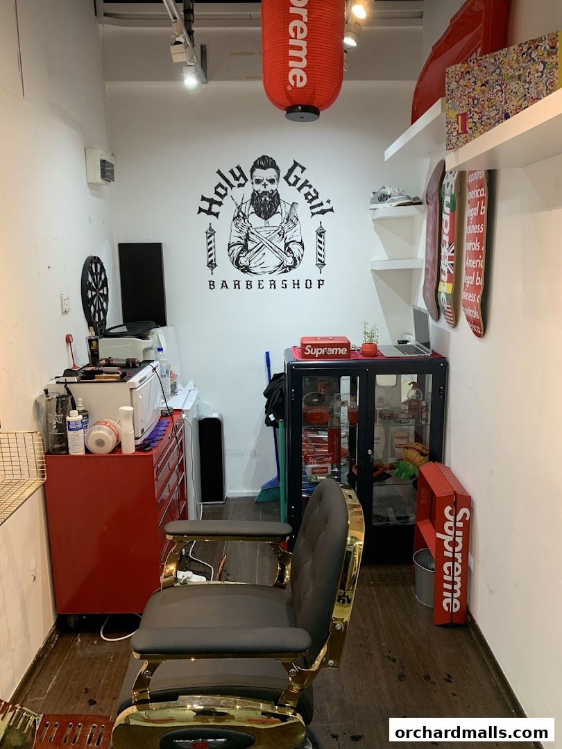 Interior of Holy Grail Barbershop with a barber chair, logo, and decor.