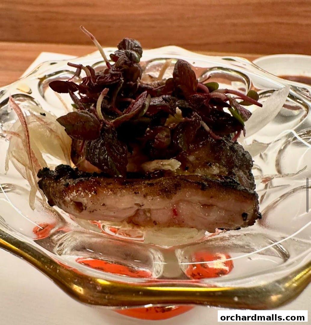 A close-up of a beautifully plated dish with grilled meat and fresh greens.