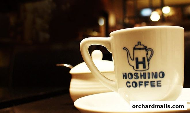 A close-up of a Hoshino Coffee cup with its logo, next to a sugar bowl.